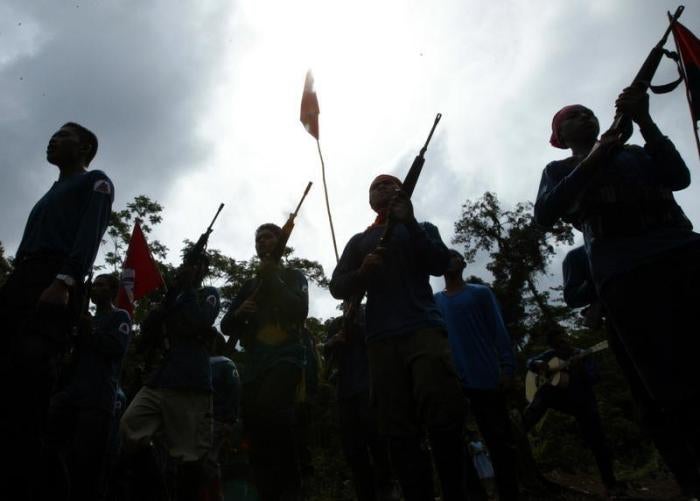 Members of the New Peoples Army (NPA), armed group of the Communist Party of the Philippines, are silhouetted during graduation after their military training in their jungle hideout in Lianga in southern Mindanao island March 13, 2004.