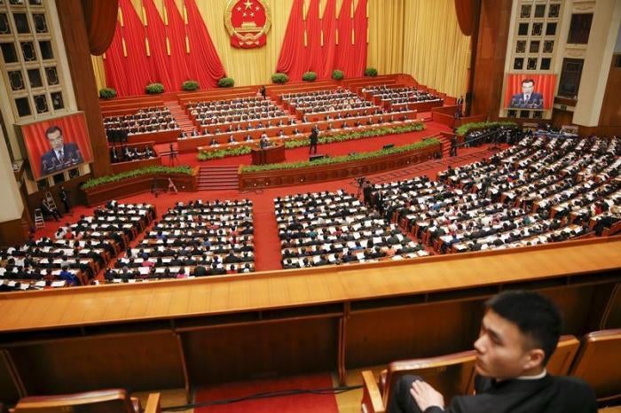A security officer sits guard as Chinese Premier Li Keqiang gives a speech during the opening session of the National People's Congress (NPC) at the Great Hall of the People, in Beijing, China, March 5, 2016.