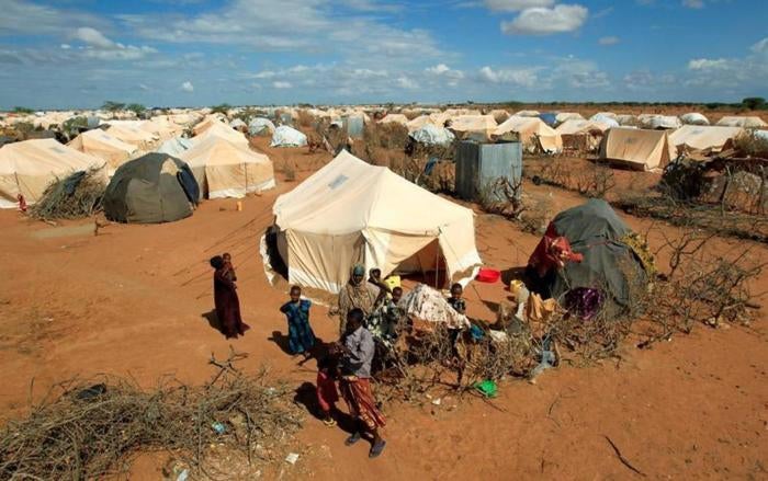 Photo: Refugees stand outside their tent at the Ifo Extension refugee camp in Dadaab, near the Kenya-Somalia border in Garissa County, Kenya, October 19, 2011. 