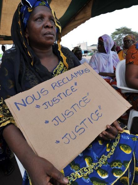 Victims of the 2010-11 post-election crisis hold placards reading 'We claim justice, justice justice' at a gathering in the Kouassai district of Abidjan on February 28, 2013, during the International Criminal Court&rsquo;s confirmation of charges hearing agains