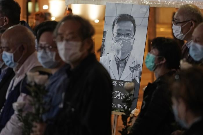 People wearing masks, attend a vigil for Chinese doctor Li Wenliang, in Hong Kong, February 7, 2020.