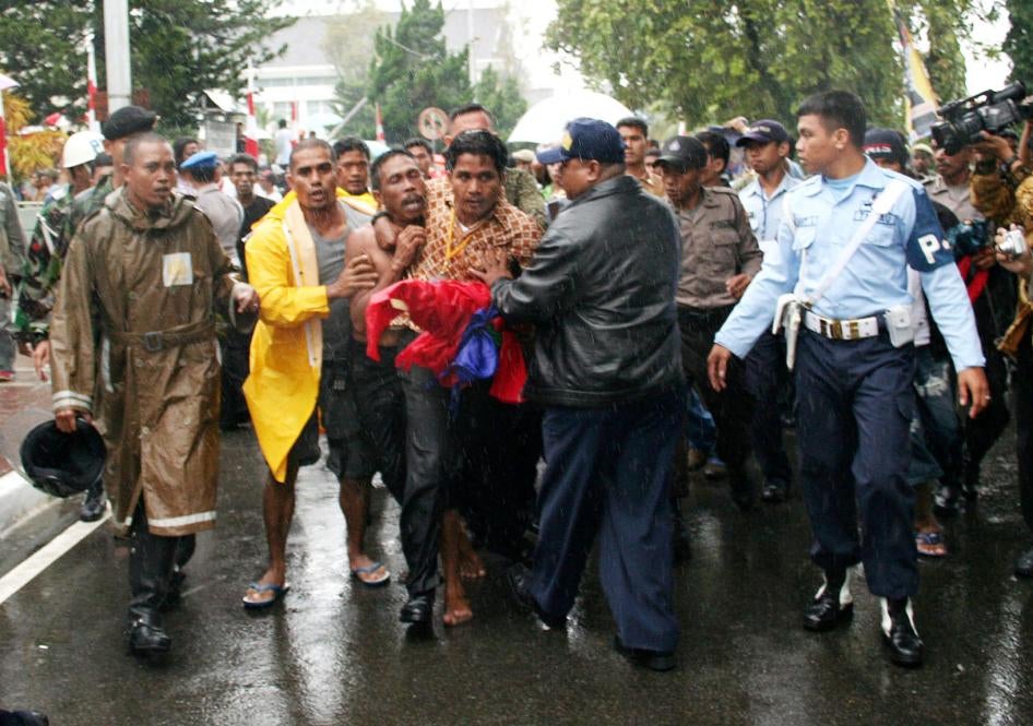 Polisi berpakaian preman menangkap Johan Teterisa (ketiga dari kiri) di luar Stadion Merdeka di Ambon pada 29 Juni 2007. Teterisa memimpin nasionalis Alifuru membentangkan bendera terlarang Republik Maluku Selatan (RMS), setelah menari tradisional cakalel