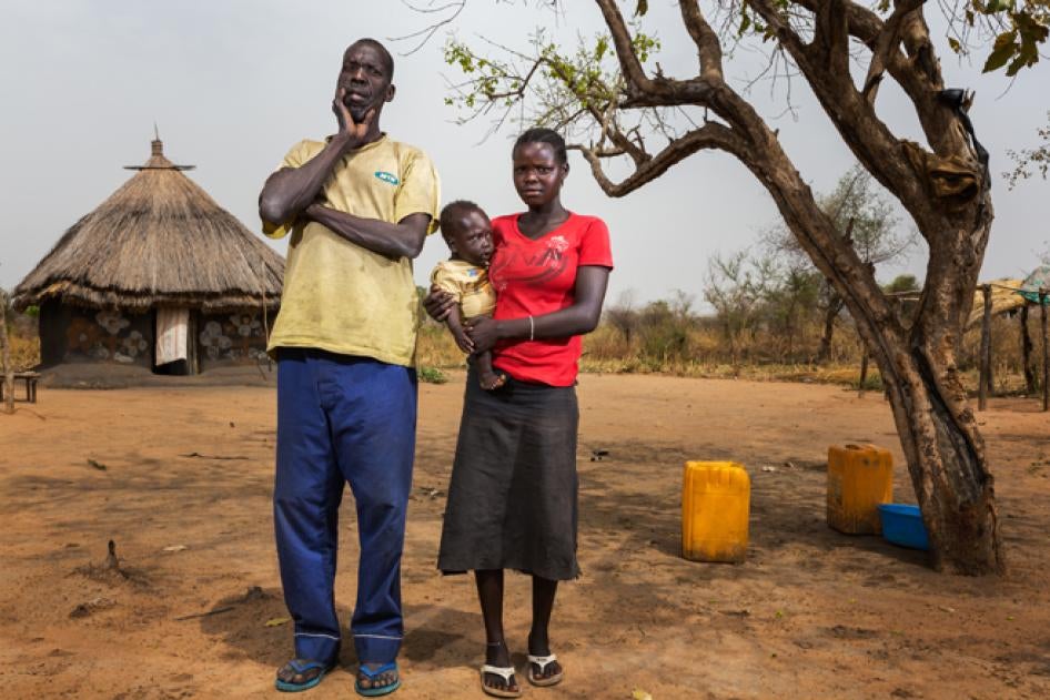 Helen, 16, stands with her husband Jade, 50, outside their home in a village near Juba.