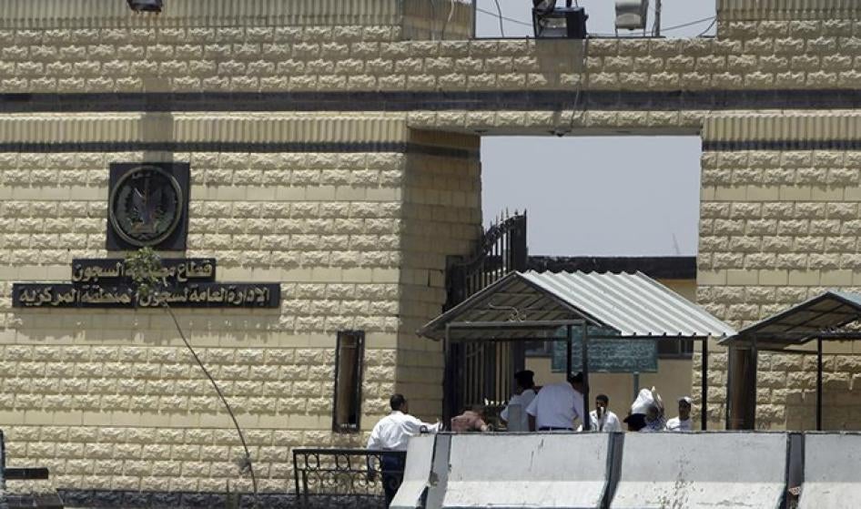عناصر شرطة وأشخاص آخرون يسيرون أمام البوابة الرئيسية لسجنة طرة في القاهرة، 4 يونيو/حزيران 2012. © 2012 رويترز