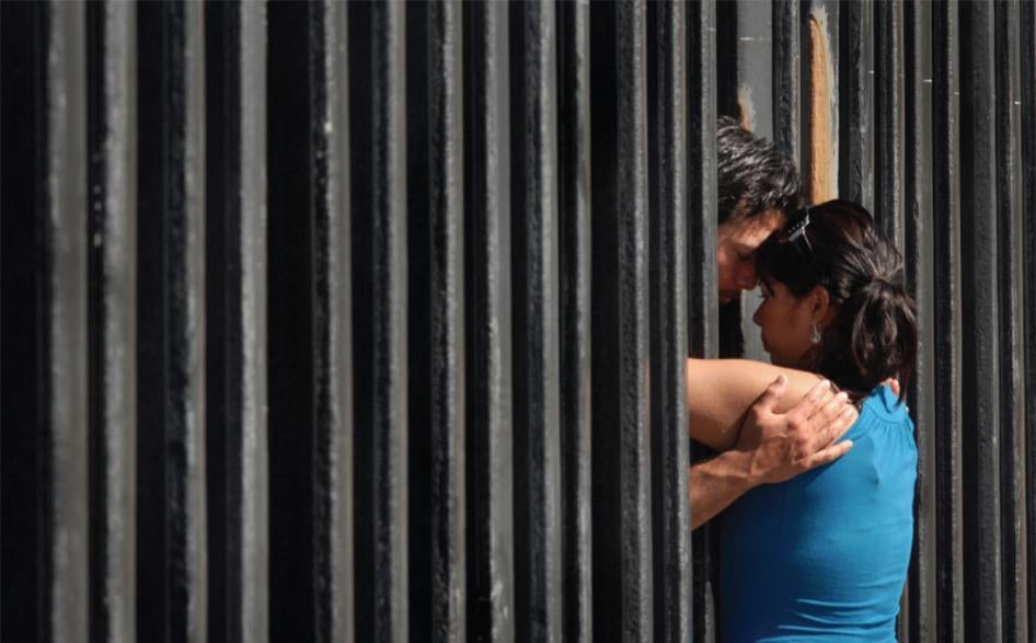 Mario Chavez, a US citizen, shares a moment with his wife, Lizeth Chvaez, a Mexican citizen, through the border fence at Playas de Tijuana.