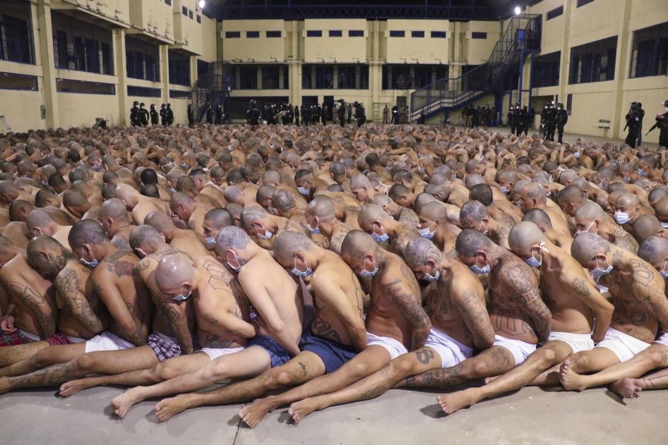 Detentos alinhados durante uma operação de segurança, sob a vigilância da polícia na prisão de Izalco em San Salvador, El Salvador, em 25 de abril de 2020.