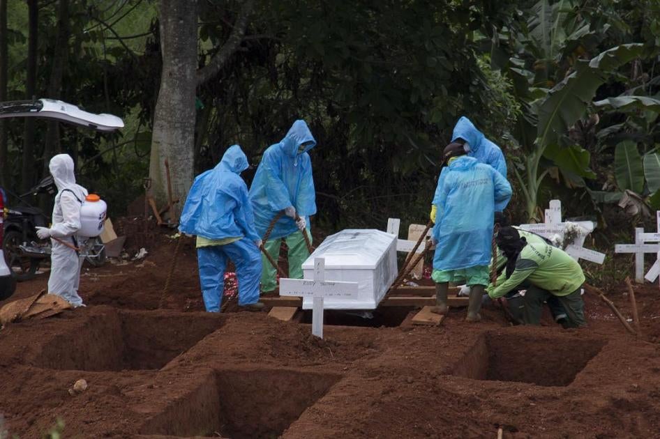 Petugas makam menguburkan jenazah korban wabah virus corona COVID-19, dalam sebuah proses pemakaman di Jakarta, Indonesia, 7 April 2020.  © 2020 Yogi Aroon Sidabariba / INA Photo Agency / Sipa USA via AP Images 