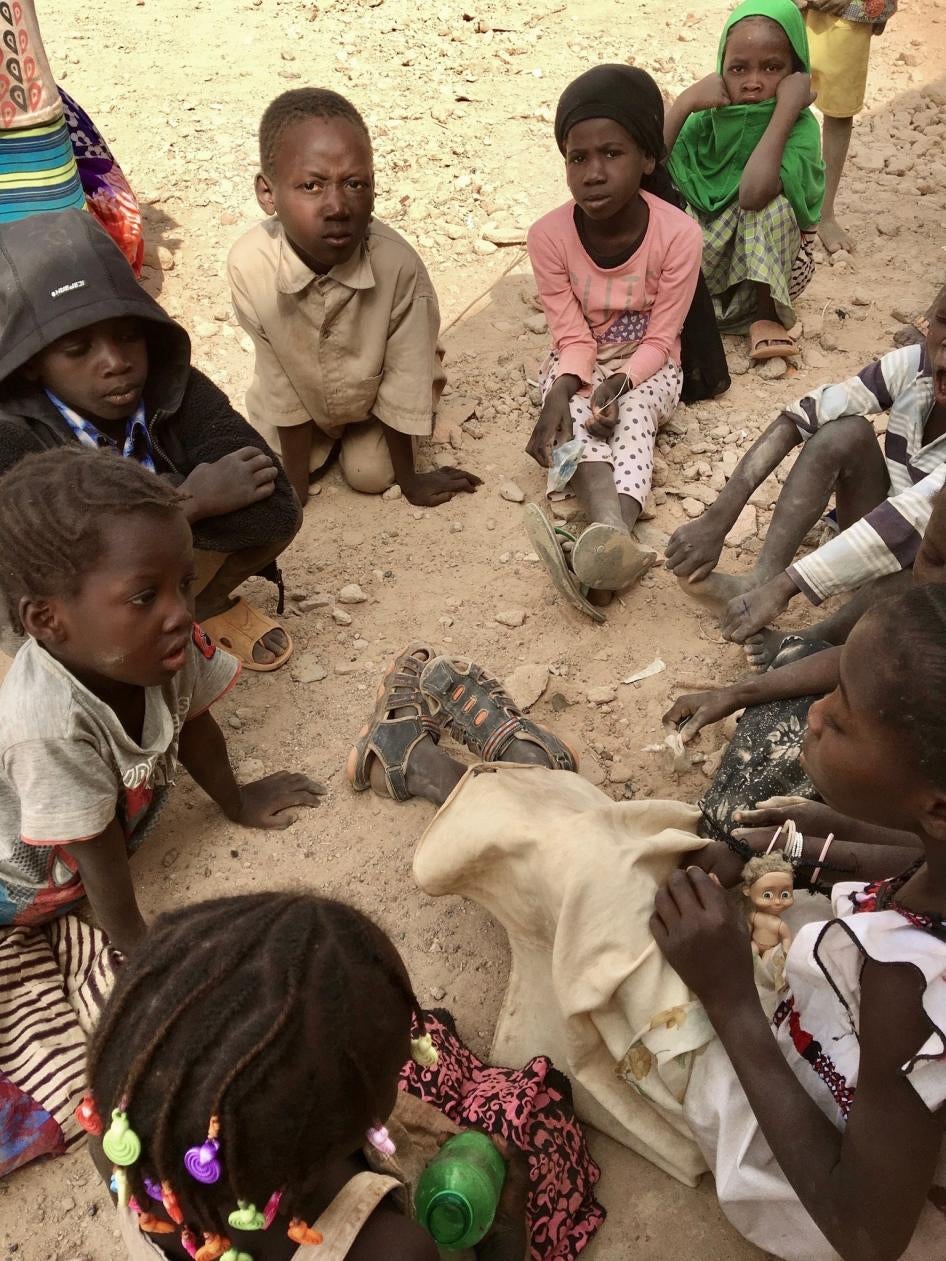 A group of children seated on the ground