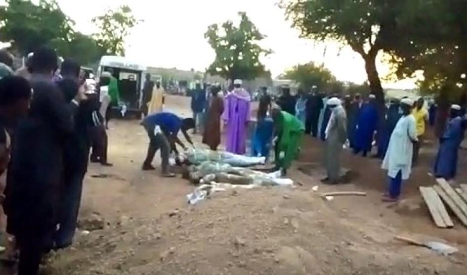 Des membres des familles de victimes, ainsi que des membres de la communauté de Fada N’Gourma, au Burkina Faso, enterrent 12 hommes qui auraient été tués après leur arrestation par des gendarmes le 11 mai 2020. 