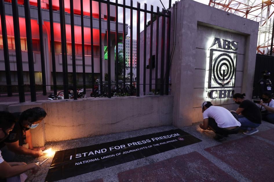 Employees light candles outside the headquarters of broadcast network ABS-CBN corp. on May 5, 2020, after the network was ordered to halt operations after its congressional franchise expired, in Quezon city, Metro Manila, Philippines.
