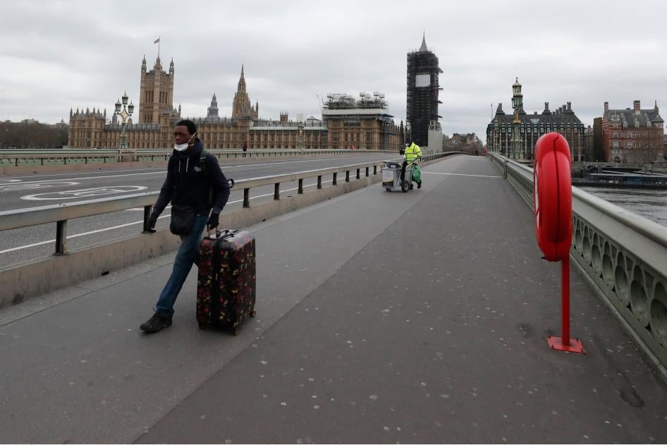 A man wheels his suitcase across Westminster Bridge looking towards the Houses of Parliament, at would normally be rush hour as the lockdown to prevent the spread of the coronavirus continues in London, March 30, 2020.