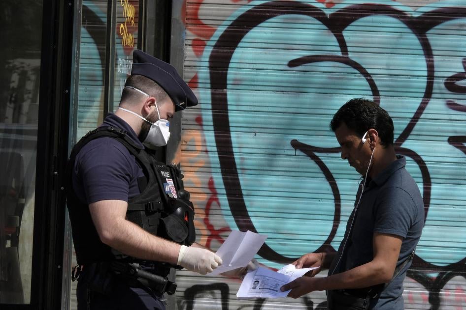 Un policier français portant un masque chirurgical de protection contre le coronavirus, contrôle les papiers d'un homme à Paris, alors qu'une quarantaine stricte est en vigueur en France pour arrêter la propagation de COVID-19. Paris, France, le 16 avril 2020. 