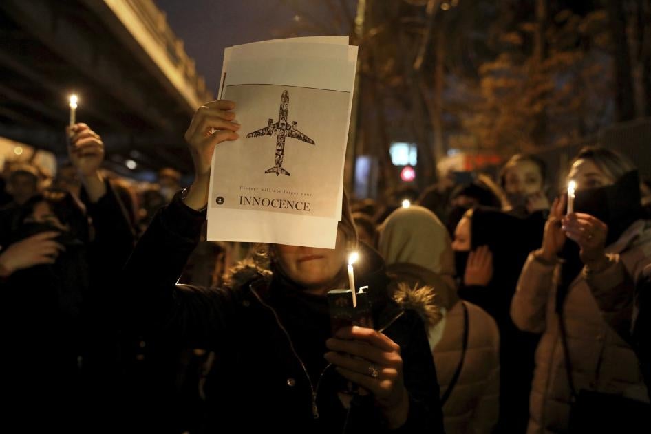 In this January 11, 2020, people gather for a candlelight vigil to remember the victims of the Ukraine plane crash at the gate of Amir Kabir University in Tehran, Iran.