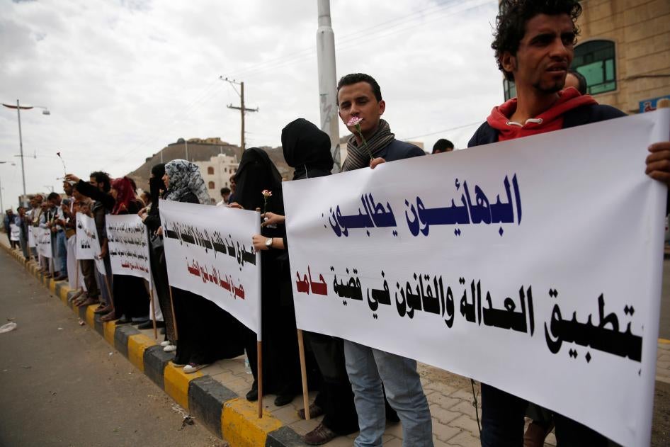 في هذه الصورة، يحتج أشخاص من الطائفة البهائية في صنعاء، اليمن، خلال جلسة محاكمة رجل بهائي مشتبه بصلاته بإسرائيل ومتهم بأنه يسعى إلى إرساء قاعدة للطائفة في اليمن، 3 أبريل/نيسان 2016. اللافتة التي يحملها المحتجون تقول: "البهائيون يطالبون بتطبيق العدالة والقانون في قضية حامد".