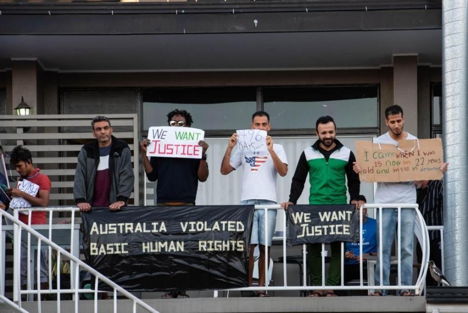 Asylum seekers and refugees hold placards during protest against their detention at Kangaroo Point Hotel in Brisbane, Australia, amid the Covid-19 crisis.