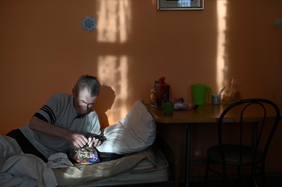 A resident in a nursing home in the village of Sosnovskoye in Omsk region, opens a bag with sweets during a visit of volunteers as part of the "Old Age for Joy" charity project.