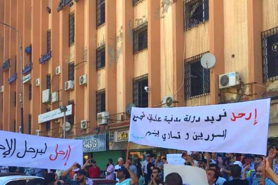 Des habitants brandissent des banderoles lors d'une manifestation liée à la crise économique à Sweida, dans le sud-ouest de la Syrie, le 9 juin 2020. 