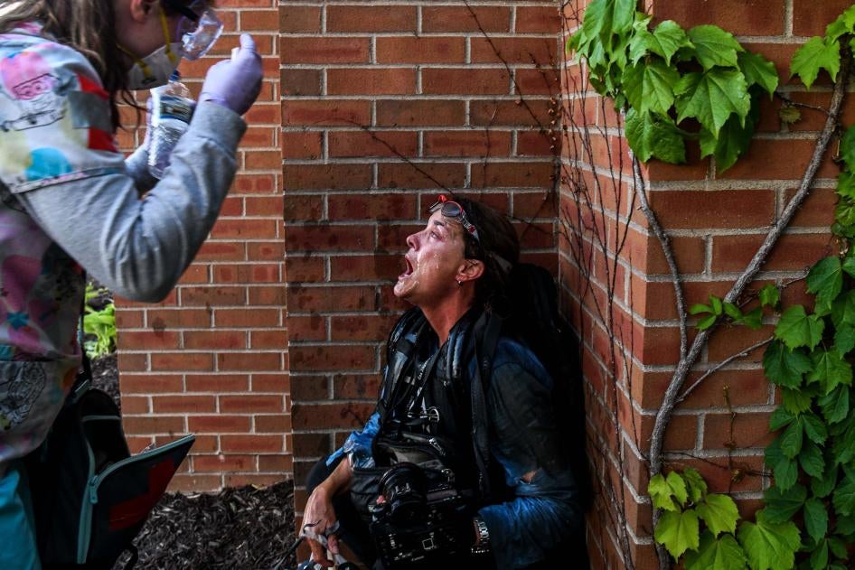 A protestor pours water over the face of woman who was injured by tear gas