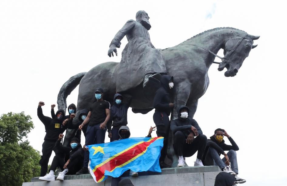 Des manifestants se tiennent sur la statue de Léopold II – l’un d’entre eux agitant le drapeau de la République démocratique du Congo – lors d’une manifestation pour la fin des injustices raciales, à Bruxelles, en Belgique, le 7 juin 2020.