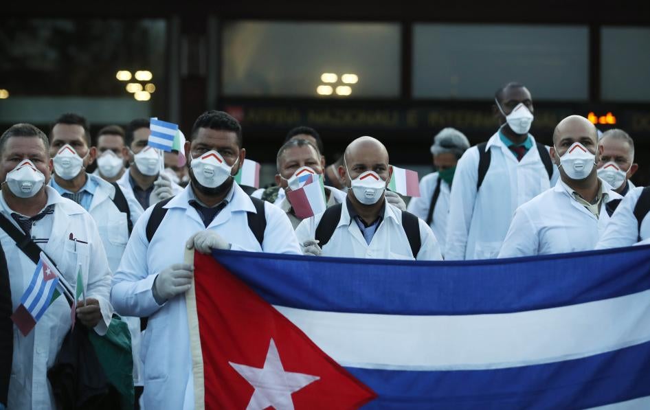 Médicos y paramédicos cubanos posan tras su llegada al aeropuerto de Malpensa en Milán, Italia, el domingo 22 de marzo de 2020. Cincuenta y tres doctores y paramédicos cubanos llegaron a Milán para ayudar con la respuesta al coronavirus.
