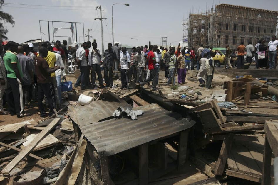 People gathered around the wreckage of a damaged road side tea shop following an explosion in Kaduna, Nigeria Monday, April 9, 2012. 