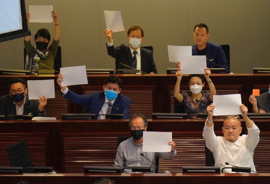 Pro-democracy lawmakers raise white papers to protest during a meeting to discuss the new national security law at the Legislative Council in Hong Kong, July 7, 2020. © 2020 AP Photo/Vincent Yu
