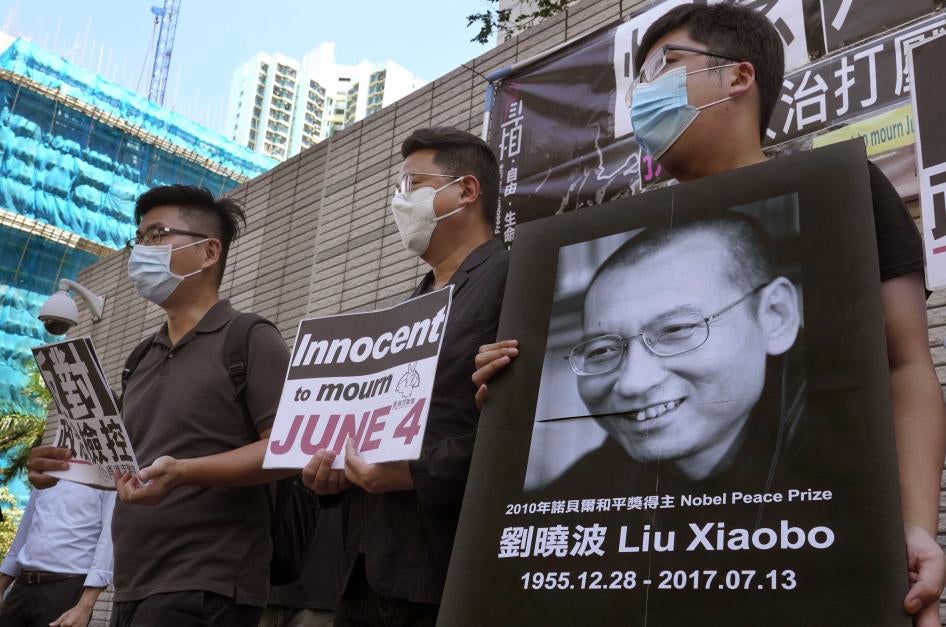 Des activistes commémorent silencieusement le troisième anniversaire de la mort du défenseur chinois des droits humains Liu Xiaobo, prix Nobel de la Paix 2010, devant un tribunal à Hong Kong, le 13 juillet 2020. L’une des pancartes fait allusion au 4 juin 1989, date du massacre de Tiananmen, suite auquel Liu Xiaobo avait été condamné à sa première peine de prison en raison de sa participation au mouvement prodémocratie.  