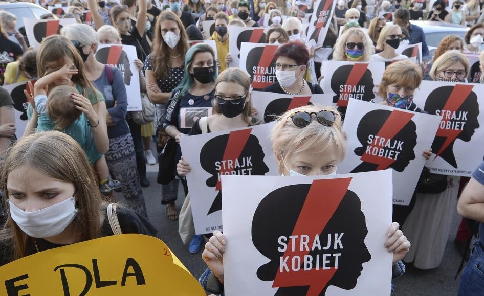 Protesters with a banner reading "Women's Strike" take part in a rally against the Polish government’s plans to withdraw from the Istanbul Convention on prevention and combating of domestic violence, in Warsaw, Poland, July 24, 2020. © 2020 AP Photo/Czarek Sokolowski