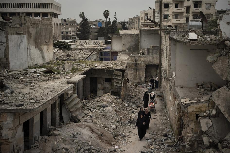 نساء يمشين في حي متضرر بشدة جراء غارات جوية في إدلب، سوريا، 12 مارس/آذار 2020. © 2020 أسوشيتد برس/فيليبي دانا 