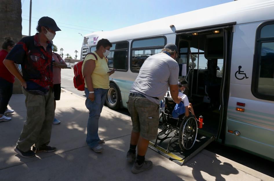 Patrons get on an express bus set up by the city Phoenix, Arizona, to take people to a heat relief station inside the Phoenix Convention Center, May 29, 2020.