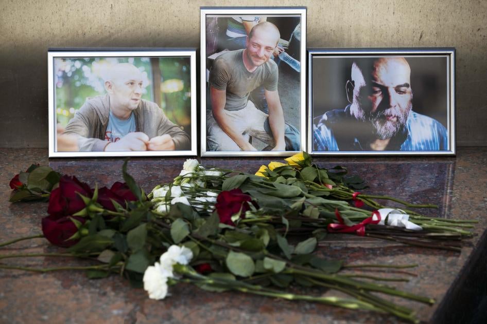 Des fleurs sont déposées devant les portraits des journalistes assassinés Alexander Rastorguyev, Kirill Radchenko et Orkhan Dzhemal, au bâtiment de l’Union des journalistes de Russie, à Moscou, le 1er août 2018.