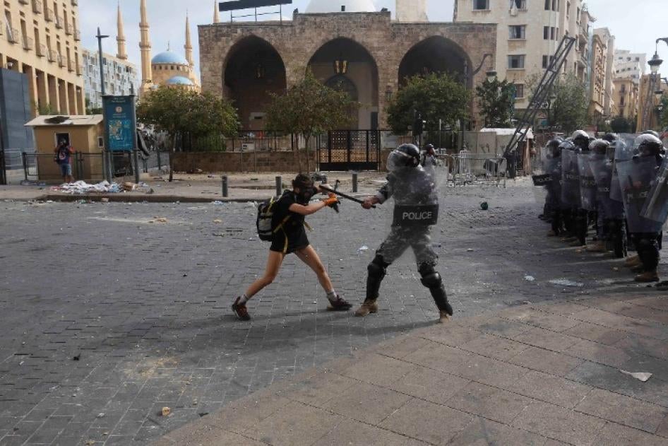 A policeman strikes a protester during anti-government demonstrations on August 8, 2020 in Beirut, Lebanon.