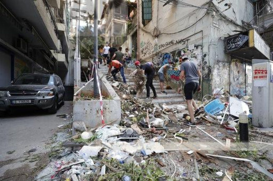أشخاص يرفعون الركام إثر انفجار هائل في بيروت، لبنان، الأربعاء 5 أغسطس/آب 2020. هزت انفجارات ضخمة وسط بيروت الثلاثاء، فسوّت بالأرض معظم أجزاء المرفأ، وألحقت الضرر بالمباني، ونسفت النوافذ والأبواب بينما ارتفعت غيمة دخان عملاقة على شكل حبة فطر. قال شهود إن العديد من الناس جرحوا جراء الزجاج والركام المتطاير. 
