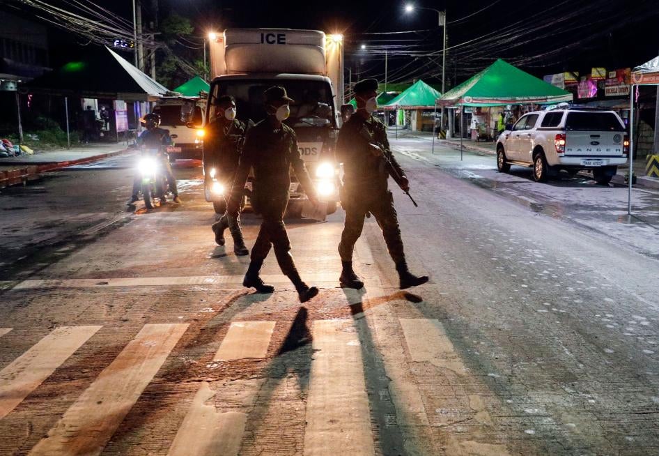 Filipino army troopers patrol a street in the Philippines in the early morning, March 15, 2020. 