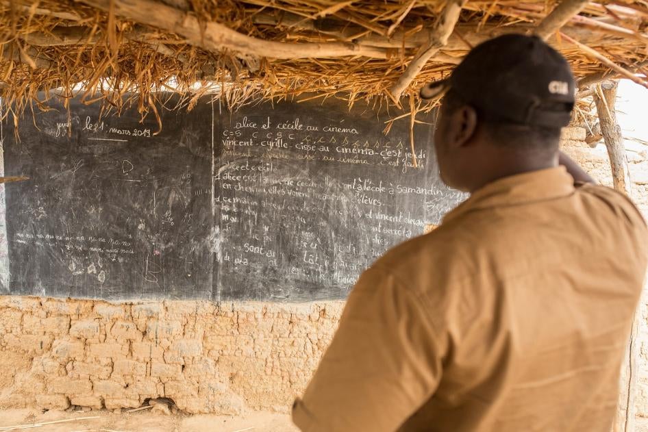 Un homme regarde un tableau dans une école qui a été abandonnée après une attaque par un groupe armé dans le nord du Burkina Faso, début 2019.