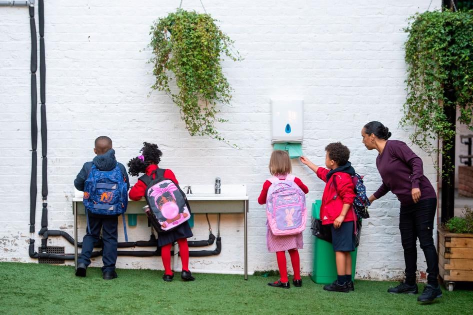 Students wash their hands as they arrive on the first day back to school at Charles Dickens Primary School in London, England, September 1, 2020.
