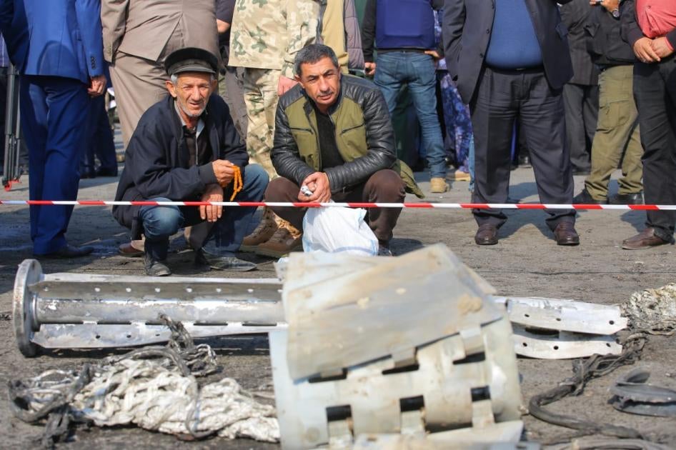 Des habitants de Barda, en Azerbaïdjan, rassemblés devant les fragments d'une roquette à sous-munitions Smerch ayant frappé cette ville, le 28 octobre 2020. 