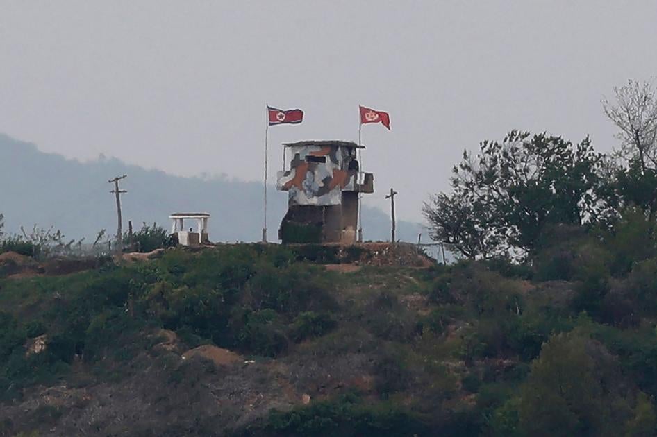 Северокорейский военный блокпост с развевающимся на ветру государственным флагом (слева). Фото сделано из южнокорейского города Пхаджу, на границе с Северной Кореей. 3 мая 2020 г.