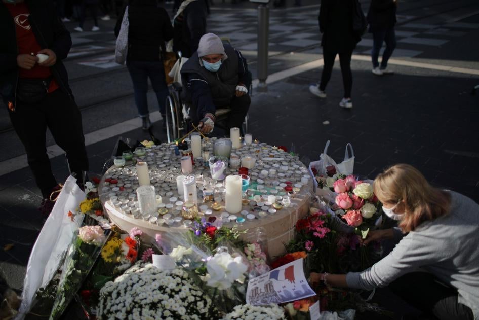 Des personnes déposent des fleurs en hommage aux victimes devant l'église Notre-Dame de Nice, en France, le 30 octobre 2020.