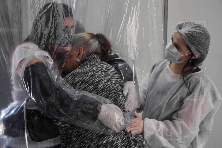 Une femme étreint sa mère âgée de 85 ans, à travers un mince rideau en plastique installé pour éviter le risque de propagation du Covid-19, dans une maison de retraite à São Paulo, au Brésil, en juin 2020.