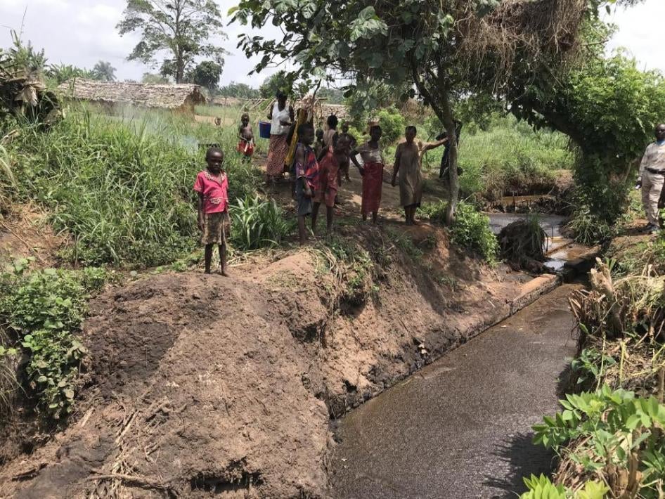 Les habitants du village de Mindonga sur les rives des effluents rejetés par l'usine d'huile de palme PHC, une entreprise soutenue par les banques publiques de développement européennes. 2 février 2019, Yaligimba, République démocratique du Congo.