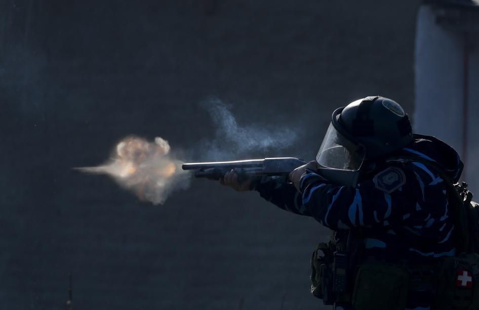 A police officer aims his weapon, as security forces fire tear gas and rubber bullets, during clashes with people after police broke up a squatters camp and evicted people living there in Guernica, Buenos Aires province, Argentina, Thursday, on Oct. 29, 2020.
