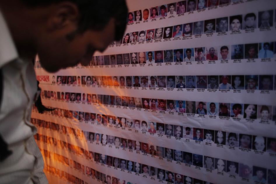 Cet homme népalais contemplait des photographies de personnes disparues lors du conflit de 1996-2006, sur une grande affiche murale exposée à Katmandou lors de la Journée internationale des victimes de disparitions forcées, le 30 août 2017.