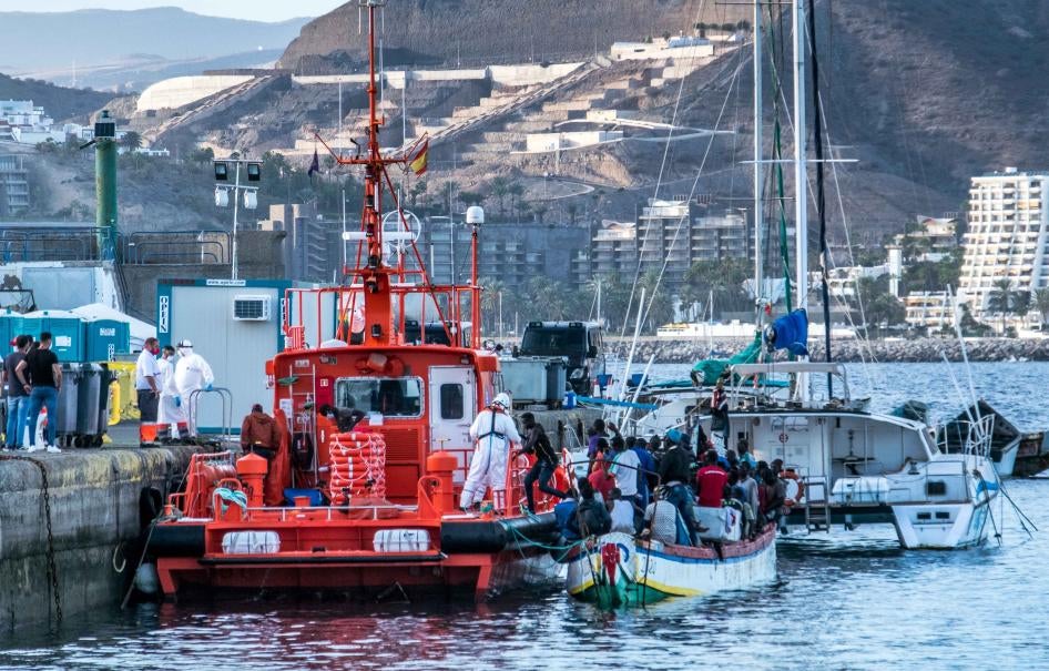 Hombres desembarcan de un barco de madera en el muelle de Arguineguín, en Gran Canaria, una de las Islas Canarias de España, después de una peligrosa travesía por el Océano Atlántico. Noviembre de 2020.
