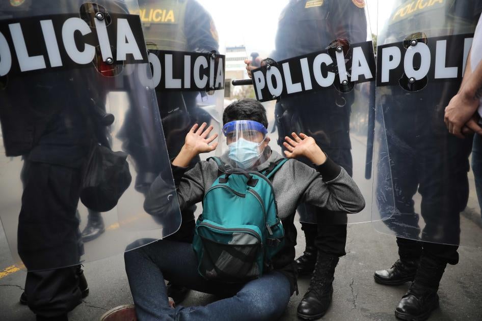 Police surround a protester in Lima, Peru, Tuesday, Nov. 10, 2020.
