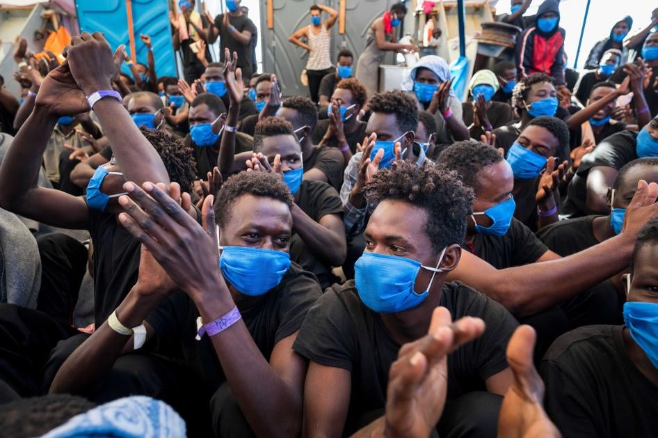 Men aboard the Sea-Watch 4, a nongovernmental rescue ship, rejoice on September 1, 2020, as they learn that they have permission to disembark in Palermo, Sicily, the next day.