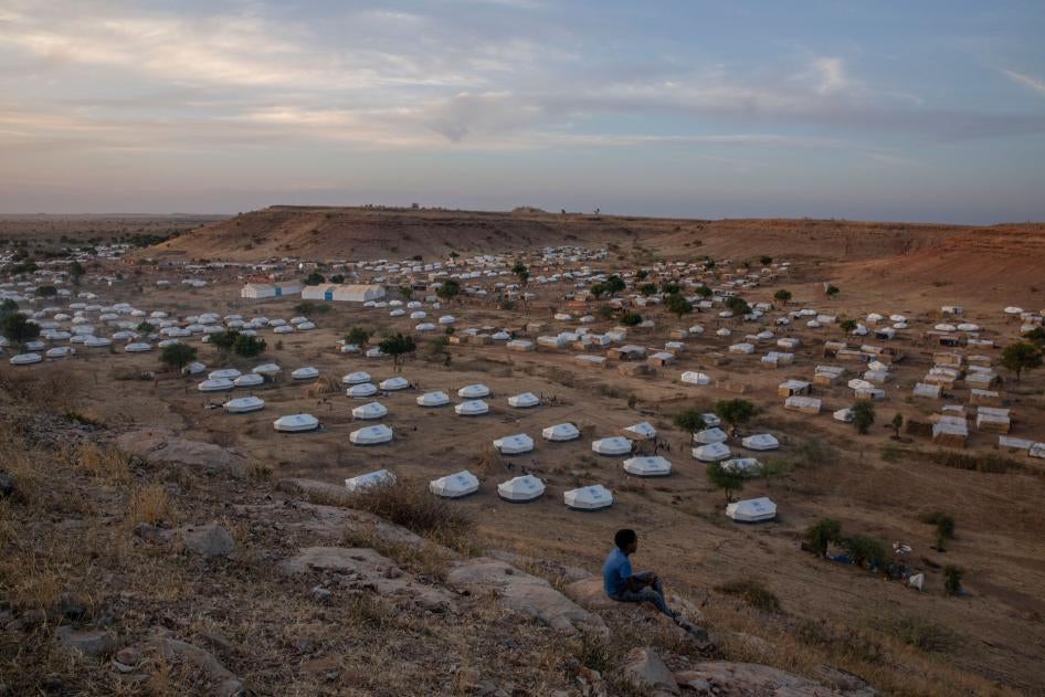 A boy sits atop a hill overlooking part of Um Raquba refugee camp, hosting people who fled the conflict in the Tigray region of Ethiopia, in al-Gadaref state, eastern Sudan, December 14, 2020. 