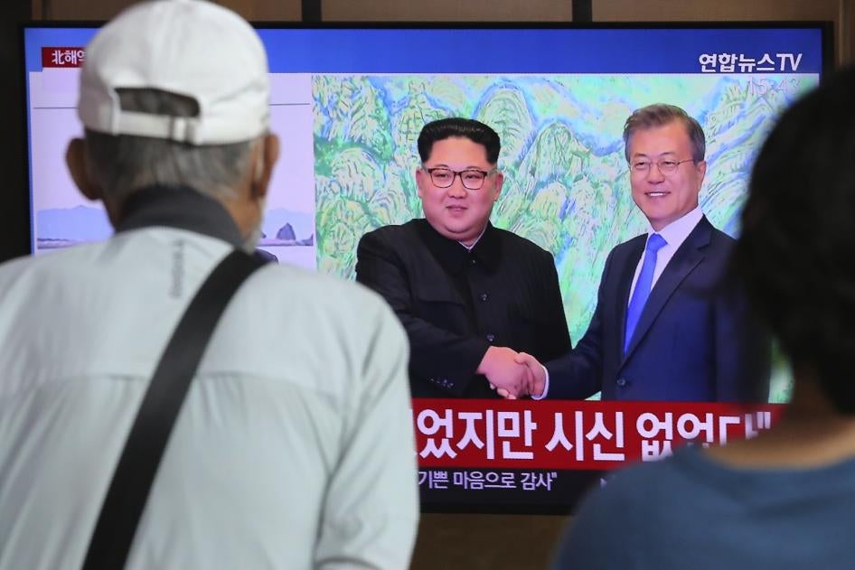 People watch a news program showing an image of North Korean leader Kim Jong Un, left, and South Korean President Moon Jae-in, right, at the Seoul Railway Station in Seoul, South Korea on Friday, Sept. 25, 2020. 