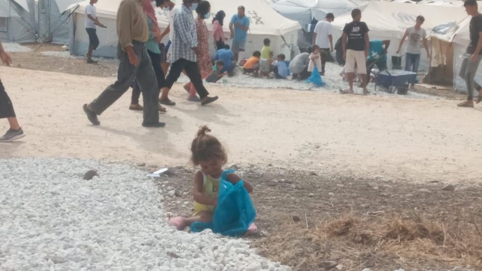 Children playing in the gravel between the tents in Mavrovouni
