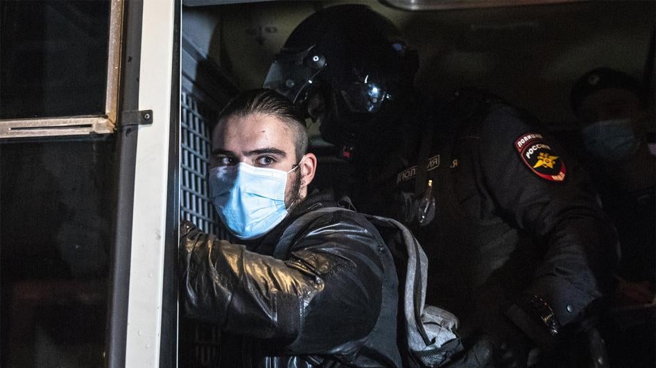 Сотрудник полиции обыскивает задержанного протестующего во время митинга за отмену результатов голосования по поправкам к Конституции, Москва, Россия.